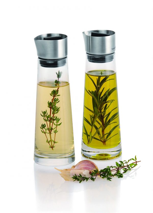 Alinjo Oil and Vinegar Set filled with oil and herbs and pictured with fresh herbs for scale