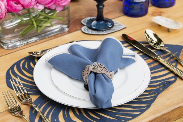 Blue Leaf Placemat with plate and silverware on it