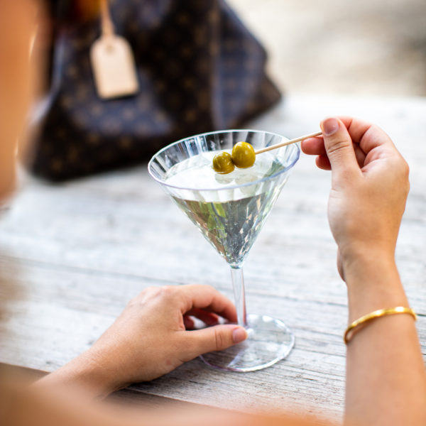 woman at a bar stirring olives in a SuperGlas Martini Glass No 12