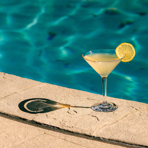 Revel Unbreakable Martini Glass beside a shimmering pool