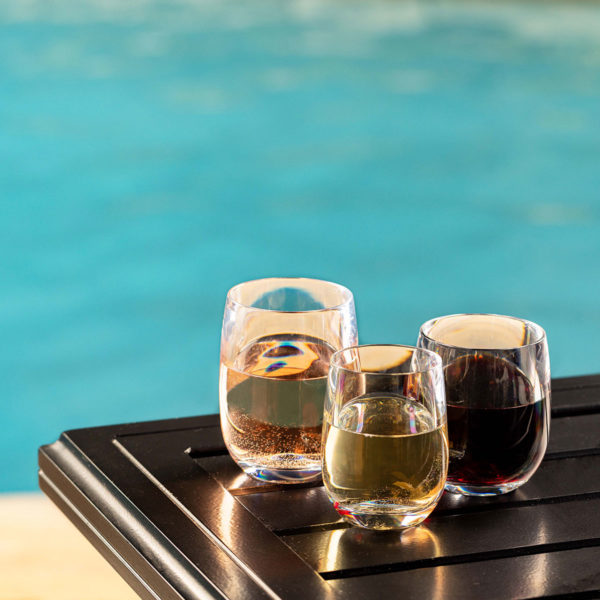 Oasis Unbreakable Stemless Wine Glasses next to a pool