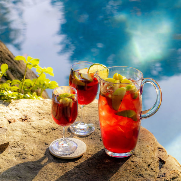 Revel wine glasses and pitcher beside a pool