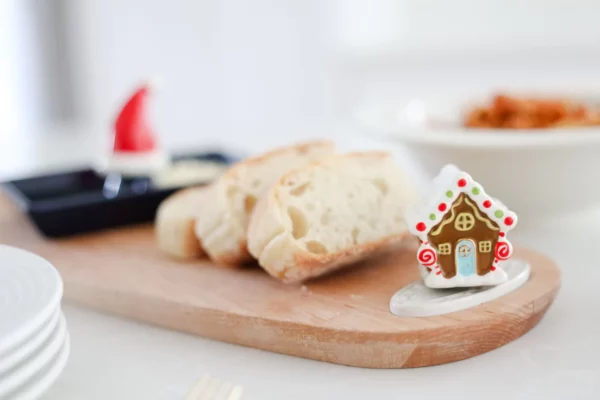 Nora Fleming Mini Gingerbread house attached to a wooden bread board
