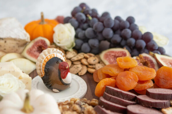 Nora Fleming Gobble Gobble Turkey Mini on a platter surrounded by dried fruits