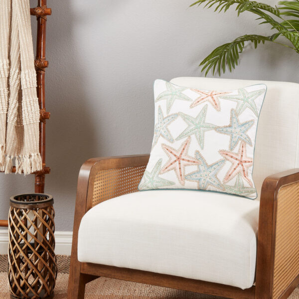 throw pillow with multi colored starfish motif pictured on an armchair
