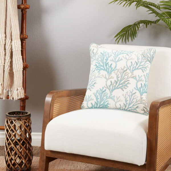 throw pillow with a blue and beige coral pattern pictured on an armchair