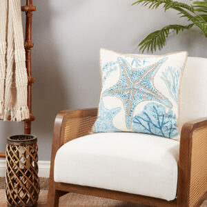 throw pillow with blue and gold starfish motif pictured on an armchair