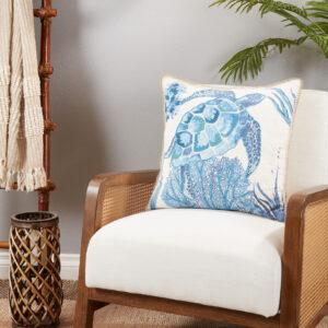 throw pillow with a blue sea turtle motif pictured on an armchair