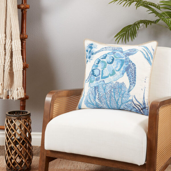 throw pillow with a blue sea turtle motif pictured on an armchair
